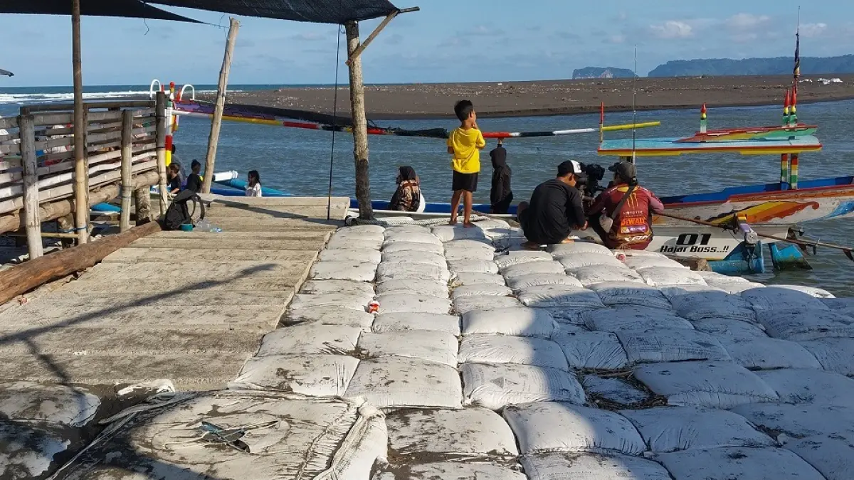 MIRIP DERMAGA: Gelombang besar mengakibatkan banyak warung di Dusun Getem, Desa Mojomulyo, Kecamatan Puger rusak, setelah warga memasang ratusan sak dan pasangan beton cor malah mirip Dermaga, (JUMAI/RADAR JEMBER)