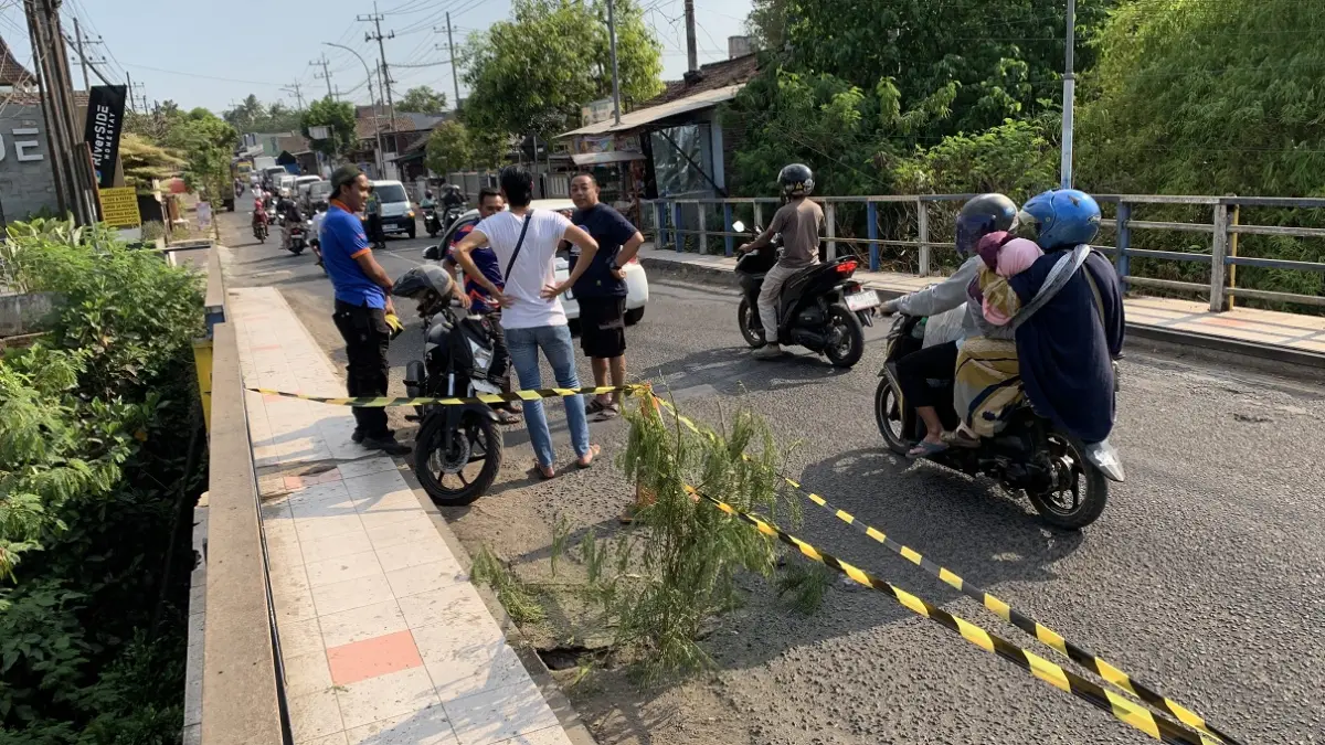 DIBATASI: Petugas BPBD Bondowoso memasang pembatas di Jembatan Koncer yang berlubang beberapa hari lalu. (ILHAM WAHYUDI/RADAR IJEN)