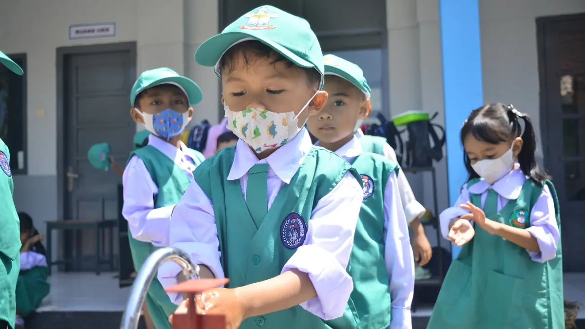 UNTUK KESEHATAN: Siswa TK Kartika IV-Secaba membiasakan anak didiknya mencuci tangan dan mengenakan masker. Dispendik Jember juga mengeluarkan imbauan mengenakan masker untuk anak didik, baik yang sedang sakit batuk pilek maupun sehat. (M. ADHI SURYA/RADAR JEMBER)