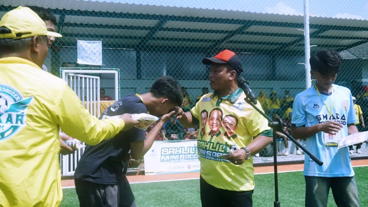 DAPAT APRESIASI: Wakil Ketua Pratama DPD Golkar Jatim Akhsanul Yaqin (dua dari kanan) menyerahkan apresiasi kepada pemain di sela-sela opening ceremony Bahlil Mini Soccer Zona 10 Jember, Kamis pagi (1/10). (SIDKIN ALI/RADAR JEMBER)