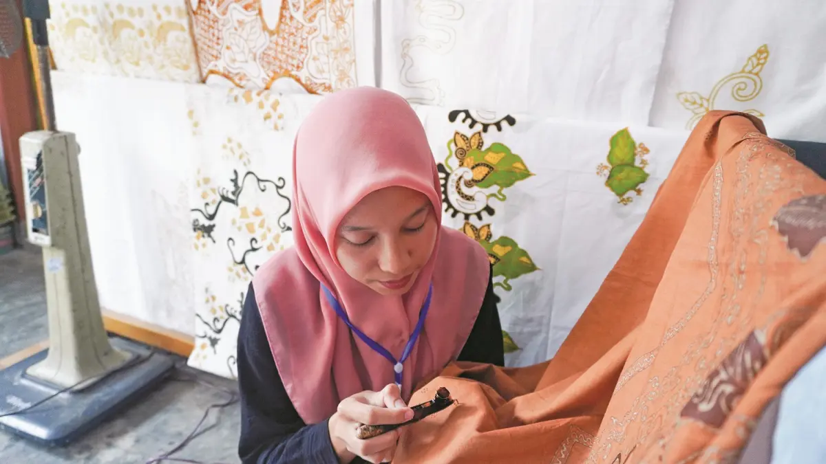 TERUS BERGELIAT: Industri batik tulis di Jember yang digawangi oleh mayoritas perempuan dengan corak khas daun tembakau. (MAULANA/RADAR JEMBER)