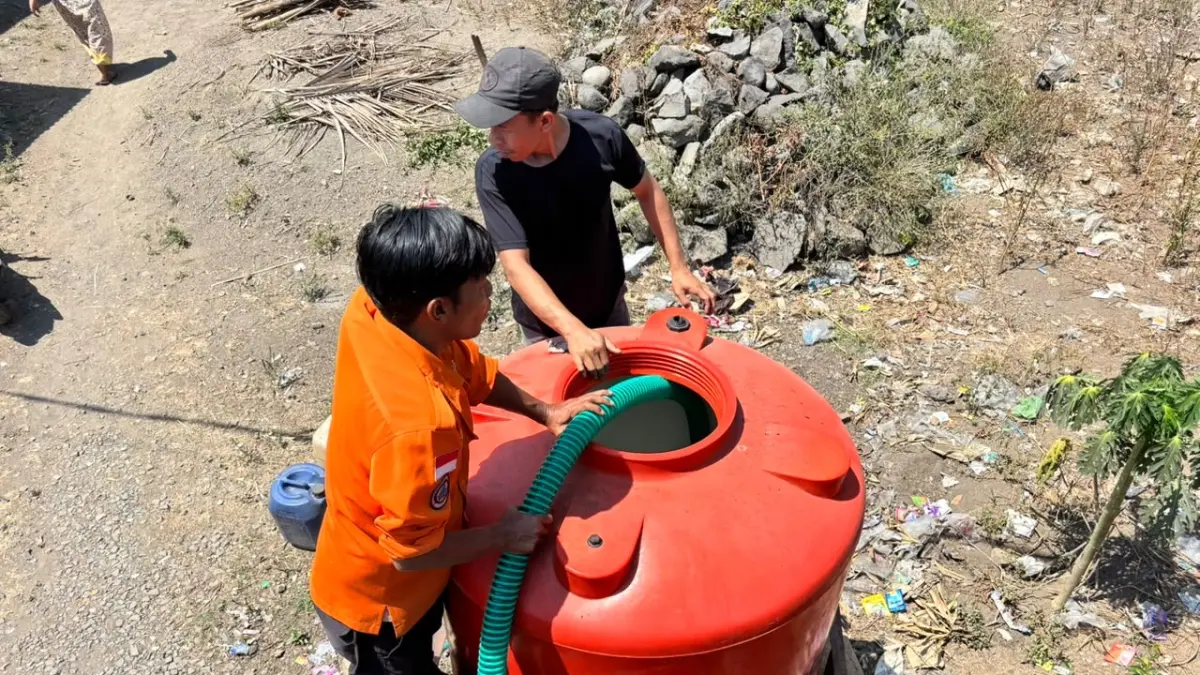 SALURKAN AIR BERSIH: Petugas BPBD Jember mengisi tandon air bersih milik warga di Dusun Gumuksari, Desa Curahmalang, Kecamatan Rambipuji, Kamis (8/10). Sebanyak 5.000 liter air bersih disalurkan untuk membantu memenuhi kebutuhan 120 KK yang terdampak kekeringan. (BPBD JEMBER)