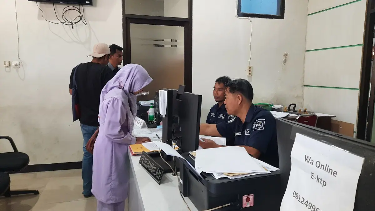 MELAYANI: Petugas saat mengarahkan warga saat melakukan perekaman. (FAQIH HUMAINI/RADAR IJEN)