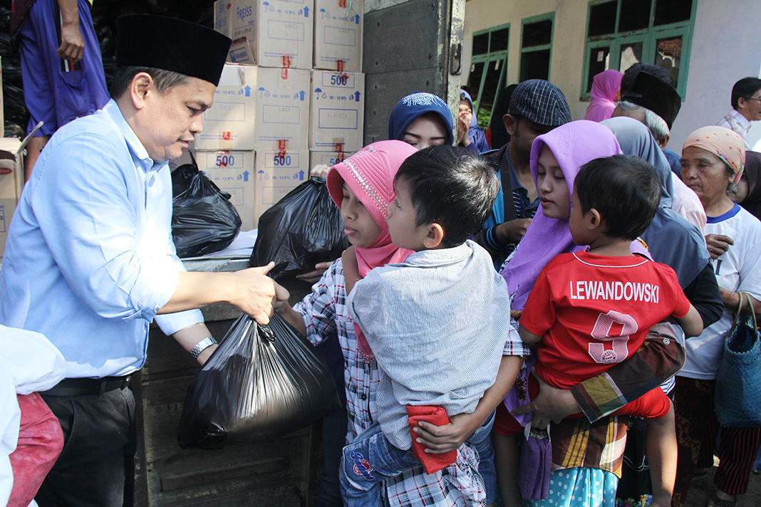 IKUT BERBAGI: H. Charles Meikyansah, tokoh masyarakat bersama Eva Yuliana, dari Staf Khusus Kemendag RI ikut membagikan paket sembako dalam acara pasar murah di halaman Ponpes Darun Najah, Dusun Krajan, Desa Gambiran, Kecamatan Kalisat Rabu (30/5) pagi.