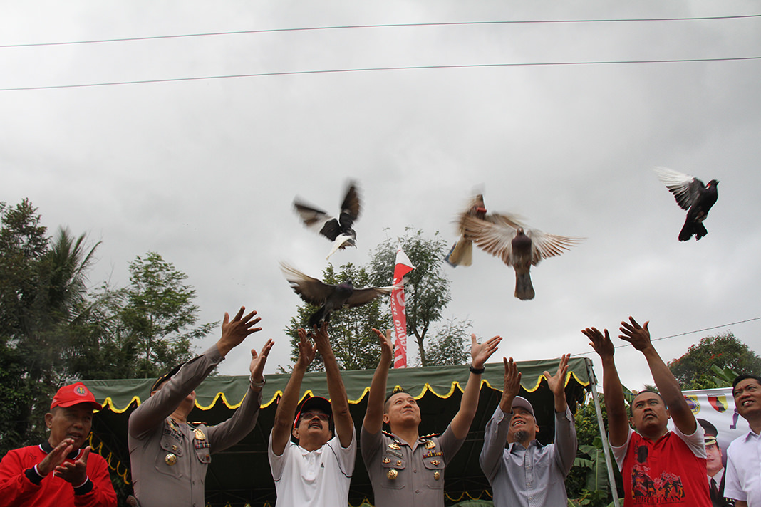 Jumai/Radar Jember  KOMPAK: Kapolres Jember AKBP Kusworo Wibowo didampingi Haji Kamil Gunawan dan anggota Muspika Arjasa saat melepas burung merpati dalam pembukaan Kejuaraan Sepak Bola Muspika Cup di lapangan Panjilaras, Desa/Kecamatan Arjasa.