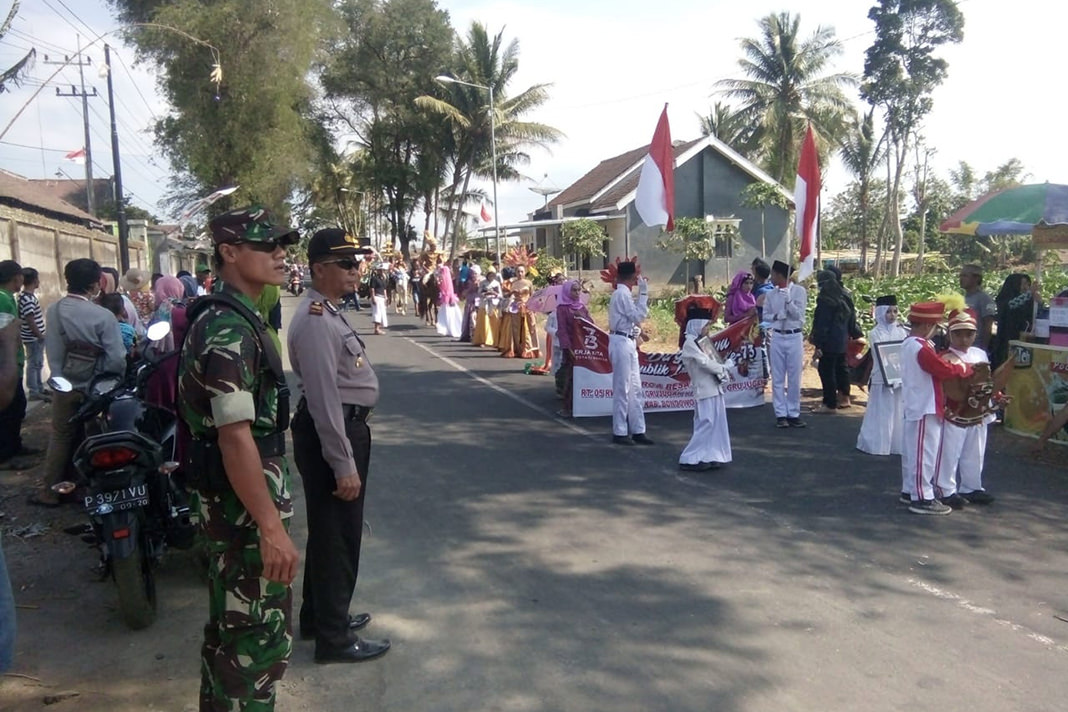 Gugah Eko Saputro/Radar Ijen  GIAT HUT RI: Kapolsek Grujugan Iptu Iswahyudi bersama anggotanya mengawal Karnaval.