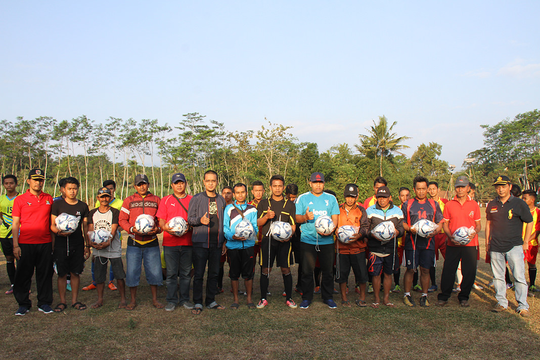 Jumai/Radar Jember  BAGI-BAGI BOLA: Dannis Barlie Halim SE (tengah berkacamata), balon Legislatif DPRD Jember dari Partai Nasdem memberikan bantuan bola pada klub sepak bola yang ada di Kecamatan Ledokombo saat pembukaan Turnamen Kades Cup di lapangan Des