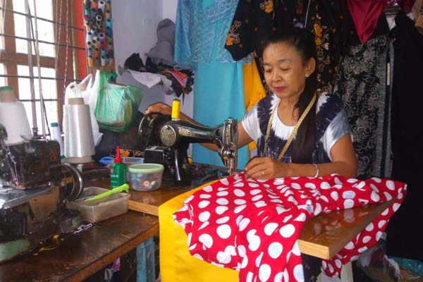 PANEN GARAPAN: Asih, warga Dusun Sidomulyo, Desa Umbulrejo, Kecamatan Umbulsari, saat menjahit baju pesanan untuk hari raya nanti.