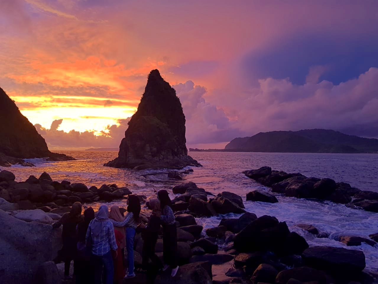 MEMPESONA: Sejumlah wisatawan tengah menikmati bias cahaya matahari yang tenggelam di Pantai Payangan. Saat sore di hari libur, tempat wisata ini cukup banyak dikunjungi para pelancong.