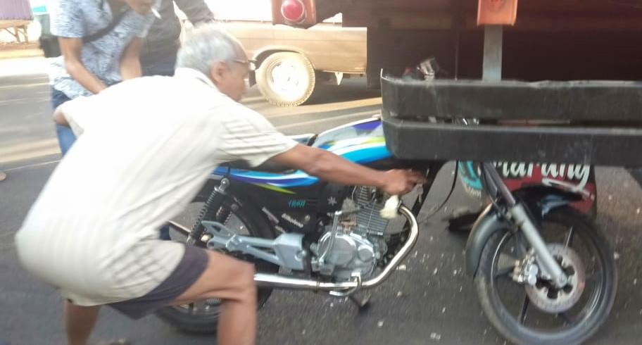 NYUNGSEP: Sejumlah warga berupaya menarik motor korban karena menempel di bak truk bagian belakang. Sementara pengendara dibawa ke IGD Puskesmas Tanggul untuk menjalani perawatan.
