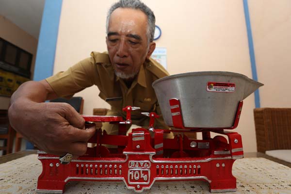 KALIBRASI: Penera UPT Metrologi Jember R Siget Pramudito mengecek tingkat presisi timbangan meja. Walau ada pedagang yang melakukan tera ulang, namun tetap ada yang bermain curang dengan menambah pemberat di timbangannya.
