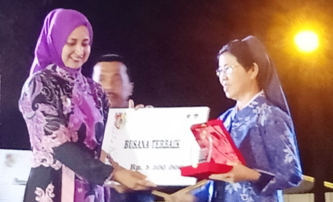 Bupati Jember menyerahkan hadiah  Busana Terbaik Karnaval Budaya Pandhalungan 2019 kepada Suster Myriam Juniati, Kepala SMP Katolik Maria Fatima Jember. (winardyasto/radarjember.id)