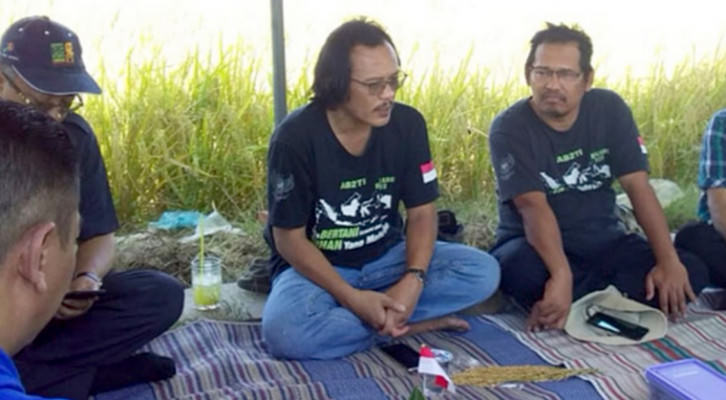 Prof Andreas Santoso (kiri) dalam sebuah diskusi di pinggir sawah.