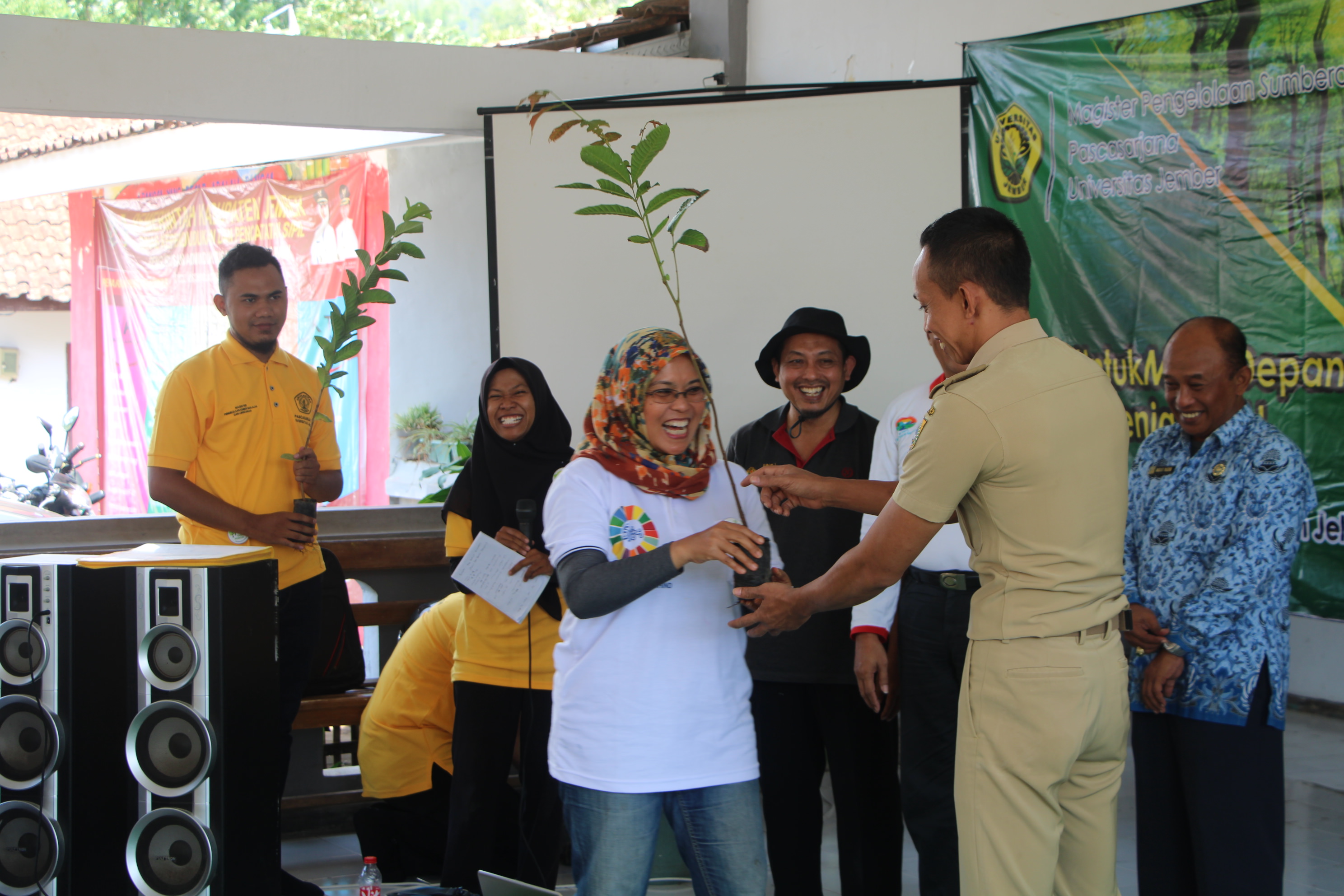 PEDULI LINGKUNGAN: Luh Putu Suciati, Ketua Program Studi PSDAP UNEJ, menyerahkan secara simbolis bibit pohon matoa kepada Abdurahman, Kepala Desa Sucopangepok.