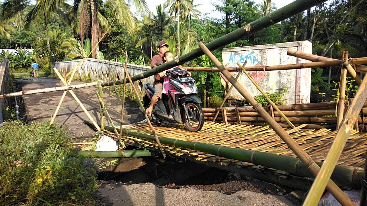 JEMBATAN SEMENTARA: Agar tidak melintas lewat rute yang lebih jauh, sejumlah warga berinisiatif membangun jembatan darurat dari bambu di Dusun Gendir, Desa Klungkung, Kecamatan Sukorambi.