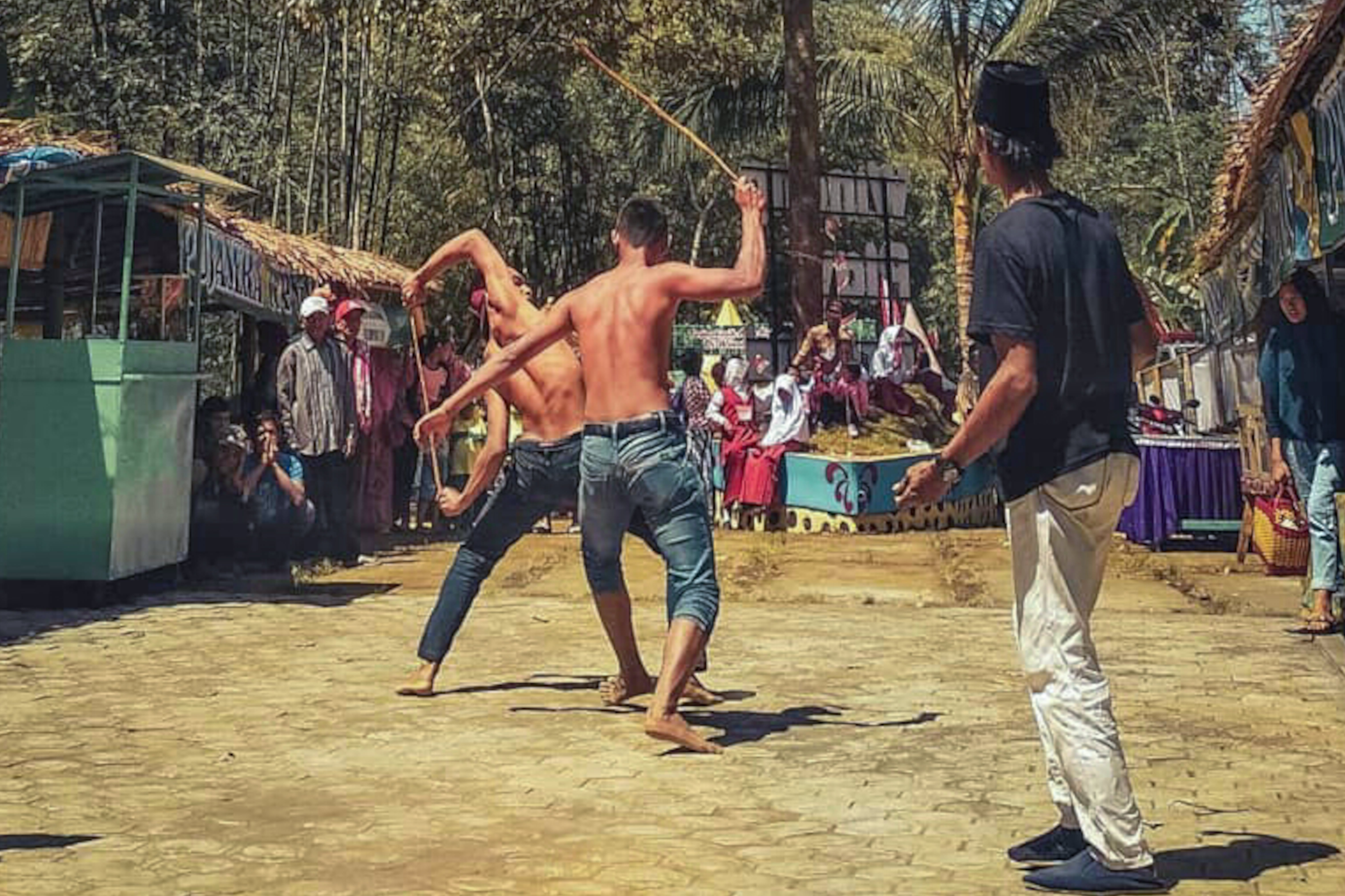 SABET KANAN: Salah satu atraksi pemain ojung yang memperagakan cara permainan kesenian ini. Konon kesenian ini lambat laun dijadikan sebagai salah satu rangkain ruwetan desa Gucialit. 