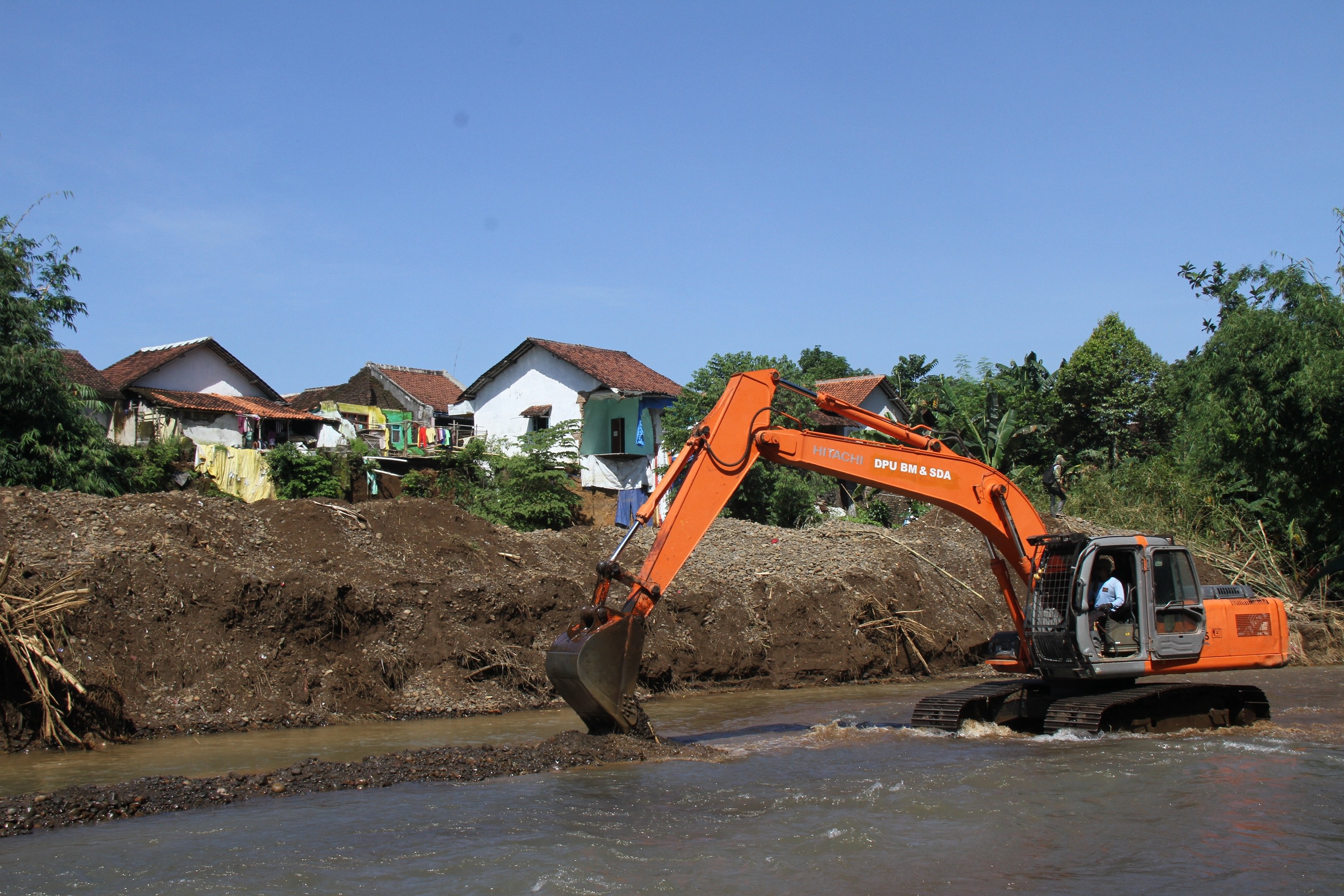 DIKERUK: Alat berat milik Dinas PU Bina Marga dan Sumber Daya Air Jember saat melakukan normalisasi Sungai Manggisan, Kecamatan Tanggul, Rabu (18/03) kemarin.