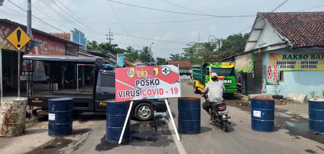 JAGA-JAGA AGAR TAK KECOLONGAN: Jalan raya yang menghubungkan Jember-Lumajang, tepatnya di Dusun Krajan, Desa Jatiroto, Kecamatan Sumberbaru, dipasang portal dengan menggunakan drum diisi air. Hal ini dilakukan untuk mencegah arus kendaraan dari maupun men
