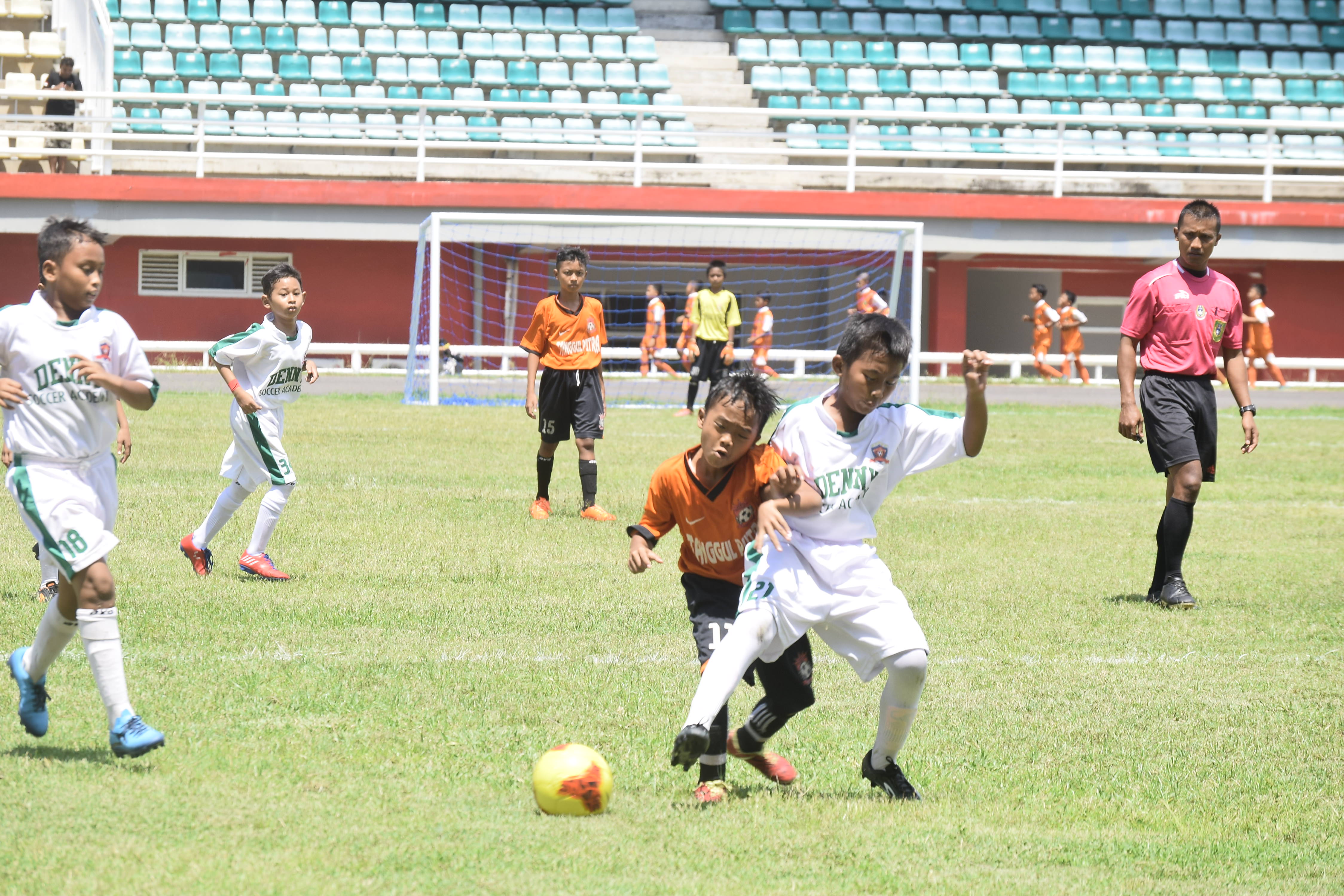 BEDAKAN MENU LATIHAN: Salah seorang pemain SSB Denny Soccer Academy (kostum putih) ketika melakoni salah satu pertandingan turnamen U-12, sebelum pandemi Covid-19, beberapa waktu lalu. Kini mereka harus latihan mandiri di rumah masing-masing.