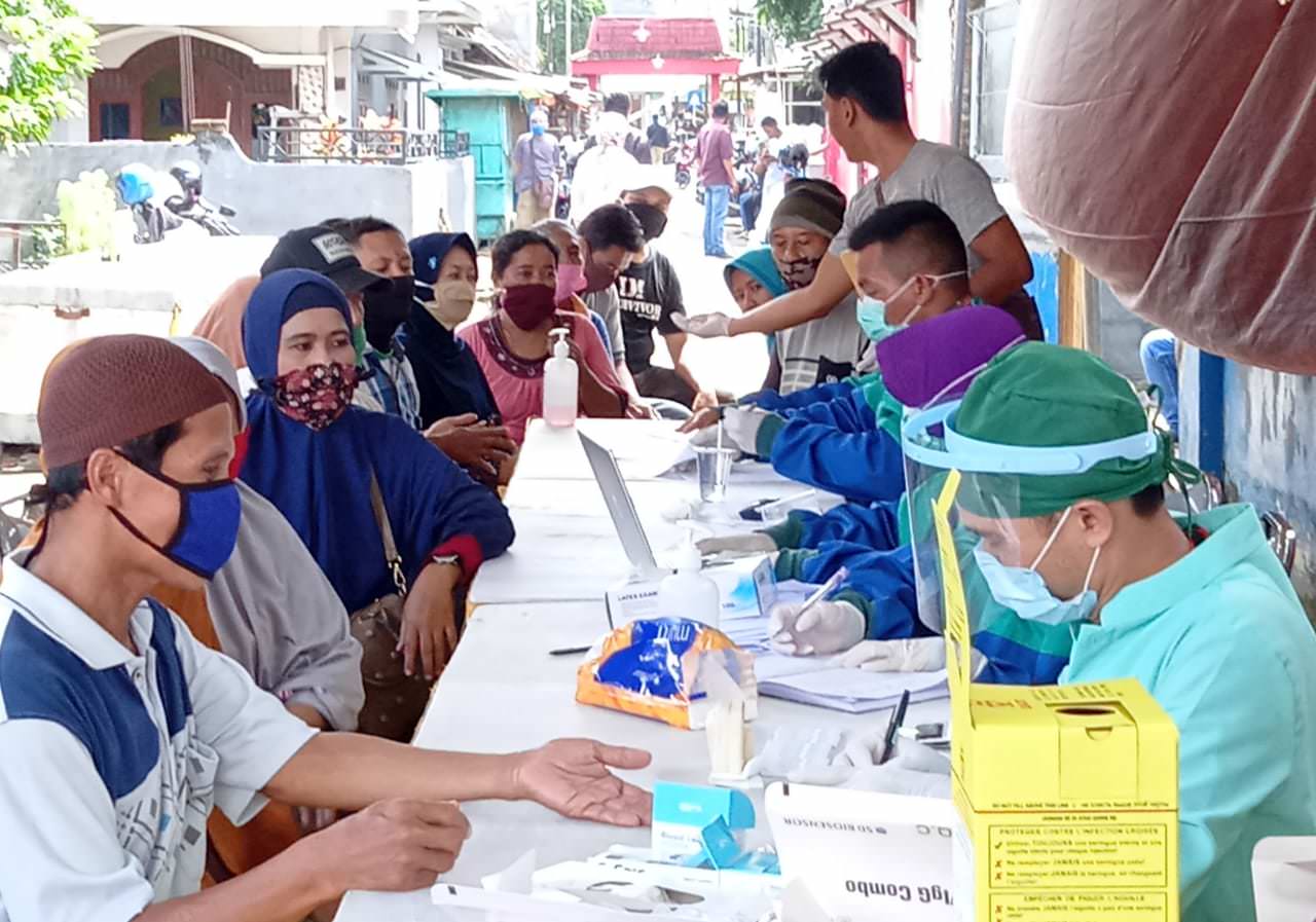 MENGULAR: Kesadaran pedagang dan warga sekitar Pasar Kepatihan mengikuti rapid tes cukup tinggi. Ini terlihat dari panjangnya antrean di meja pelayanan.