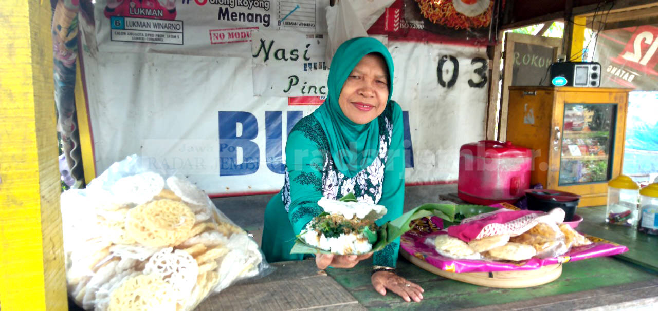 TETAP BERTAHAN: Tini alias Bu Ida, 61, warga Dusun Pasar Alas, Desa Garahan, Kecamatan Silo, sudah enam tahun berjualan nasi pincuk di depan Stasiun Garahan, Kecamatan Silo.