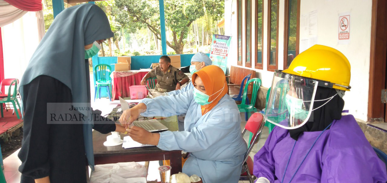 TETAP SIAGA: Petugas Puskesmas Andongsari, Kecamatan Ambulu, saat melakukan cek kesehatan pengguna sepeda motor yang melintas di Pos Covid-19 Garahan, Selasa (21/7) kemarin. 