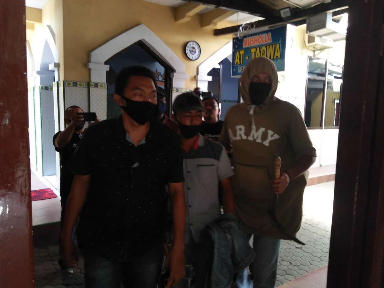 DIRINGKUS: Tersangka AS ketika dibawa ke Mapolres Lumajang oleh beberapa aparat yang berpakaian preman.