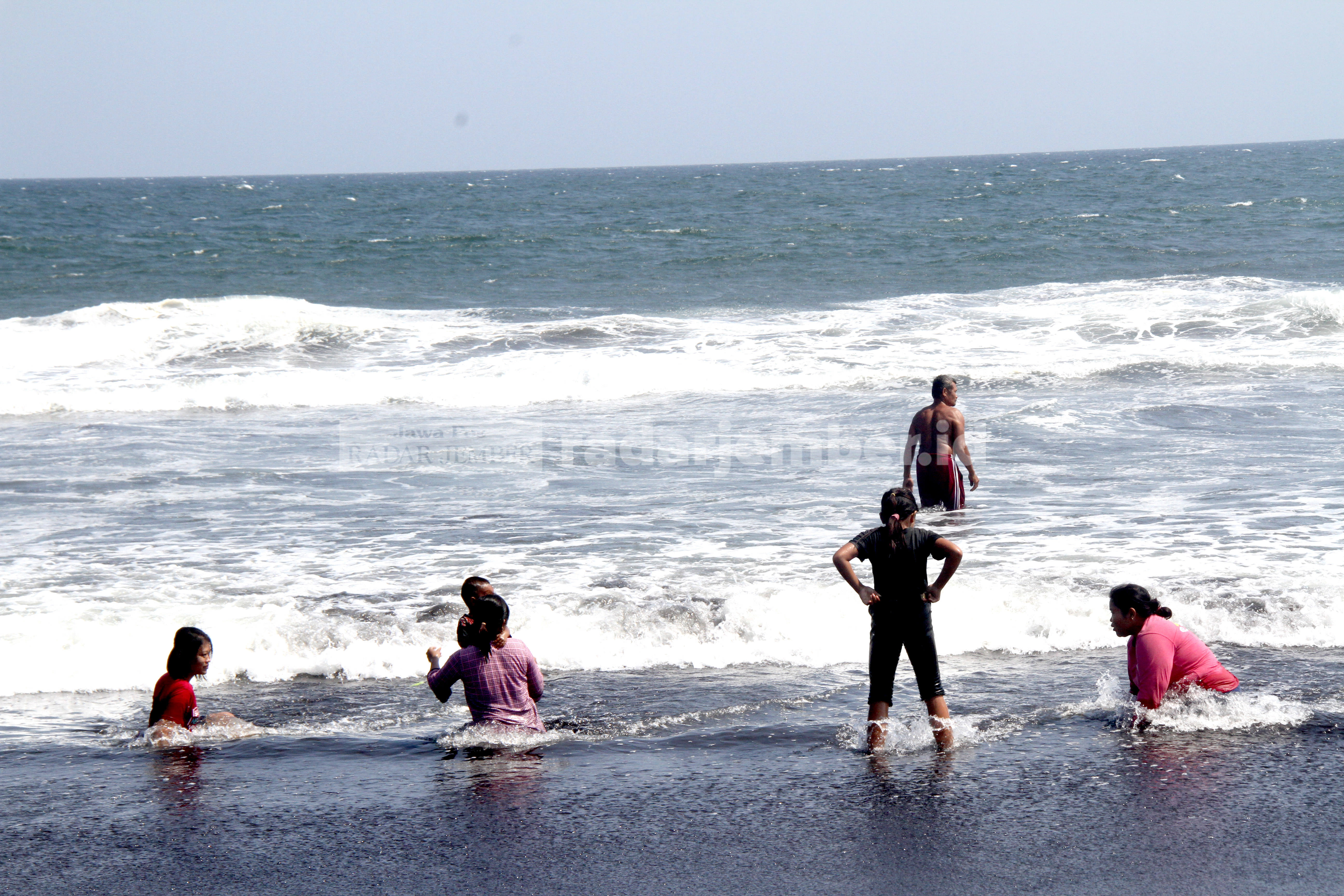 MERASA NYAMAN: Pengunjung Pantai Paseban terlihat bermain air laut di tepi pantai. Mereka tak waswas meski saat ini ombak sedang tinggi.