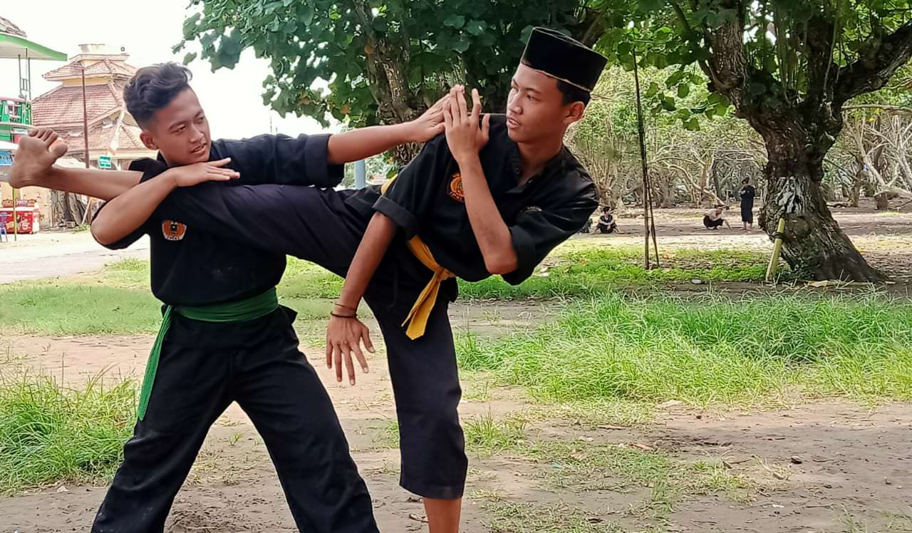 LATIHAN SERIUS: Anggota perguruan pencak silat Tjimande Cabang Jember terlihat tengah melakukan latihan di kawasan Pantai Watu Ulo.