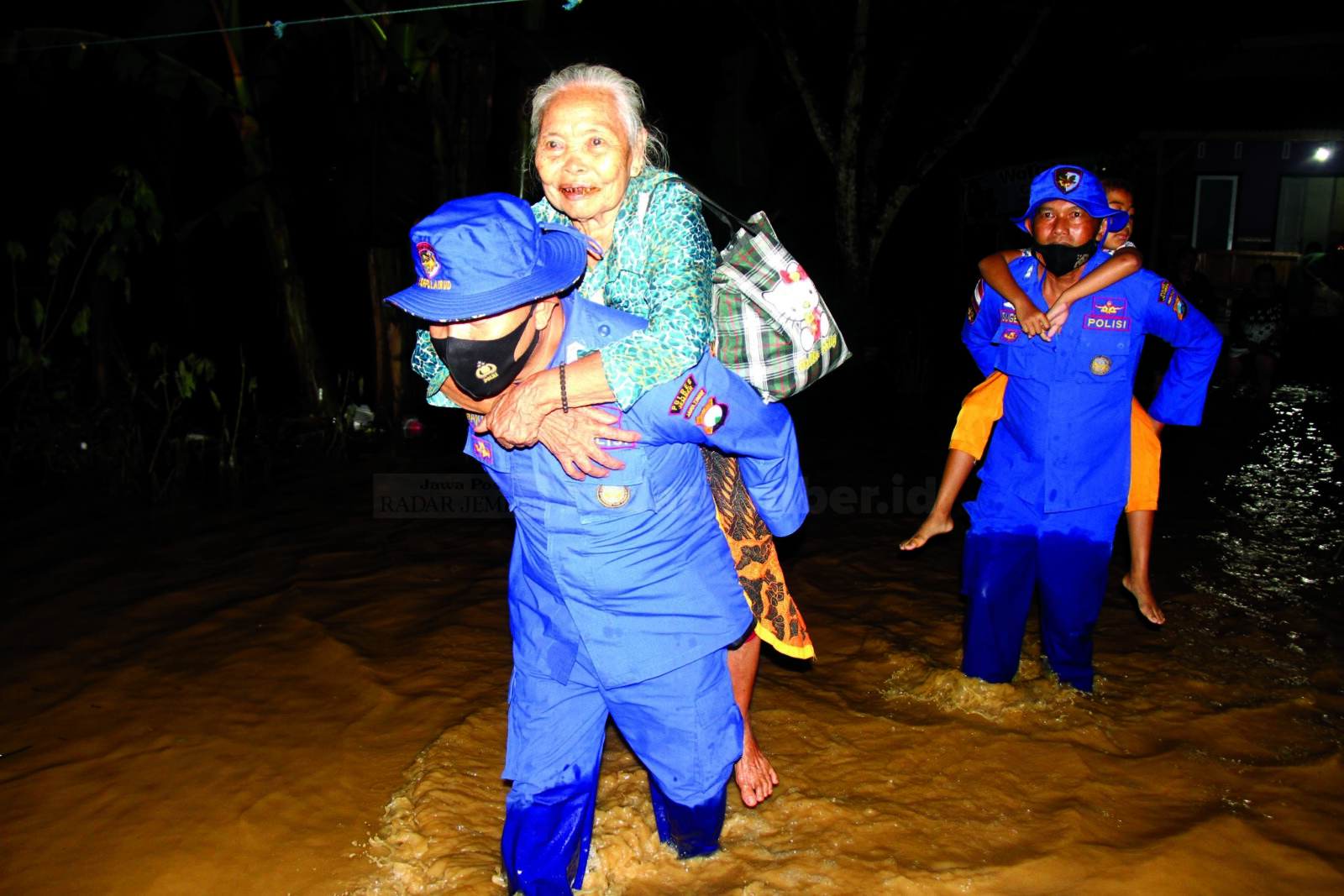 EVAKUASI: Anggota Satpol Air Polres Jember mengevakuasi lansia korban banjir yang tinggal di Gang IV, Dusun Kraton, Desa Wonoasri, Kecamatan Tempurejo, Selasa (19/1) dini hari.