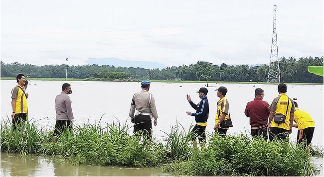 CEK LOKASI: Kapolsek Puger AKP Ribut Budiono dan Kepala Desa Wringintelu Solihin bersama jajarannya saat meninjau lokasi banjir di persawahan Desa Grenden, Kecamatan Puger, kemarin (9/1).