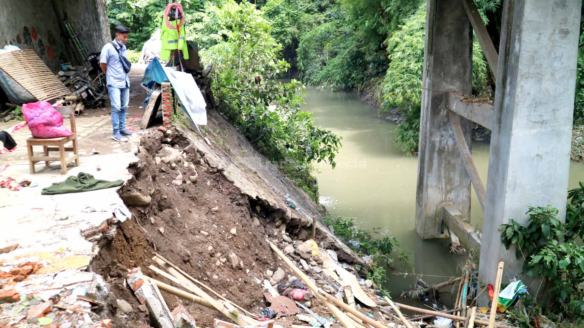 AMBROL: Kondisi plengsengan bawah jembatan menuju Jalan Sumatera. Tak hanya plengsengan yang terdampak banjir, fondasi jembatan juga. Bahkan, warga menyebut, fondasi itu sudah retak.