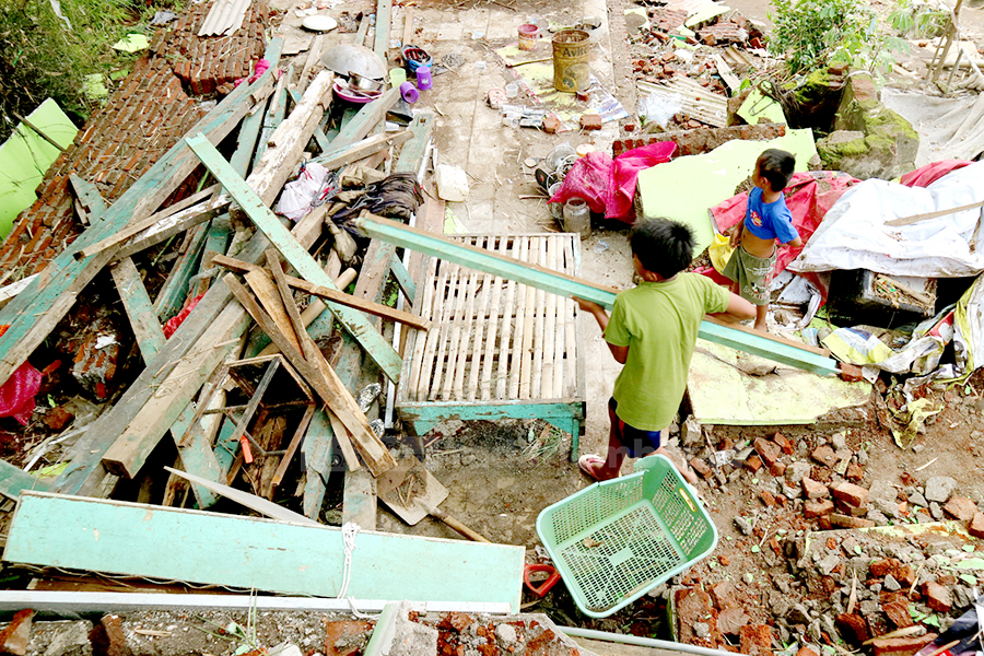 DAMPAK BANJIR: Dua bocah tengah berada di bekas bangunan yang rusak akibat diterjang banjir. Selain mengakibatkan kerugian material, bencana itu juga membuat beban psikologis. Terutama pada anak-anak.