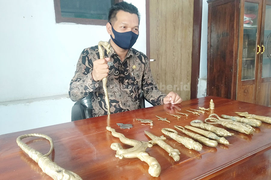 RAWAN REPLIKASI: Kepala Desa Selok Awar-Awar Kecamatan Pasirian Didik Nurhandoko saat menunjukkan puluhan benda pusaka dugaan barang purbakala yang tersimpan di kantor desa itu rawan replikasi. Sebab, terbuat dari kuningan.