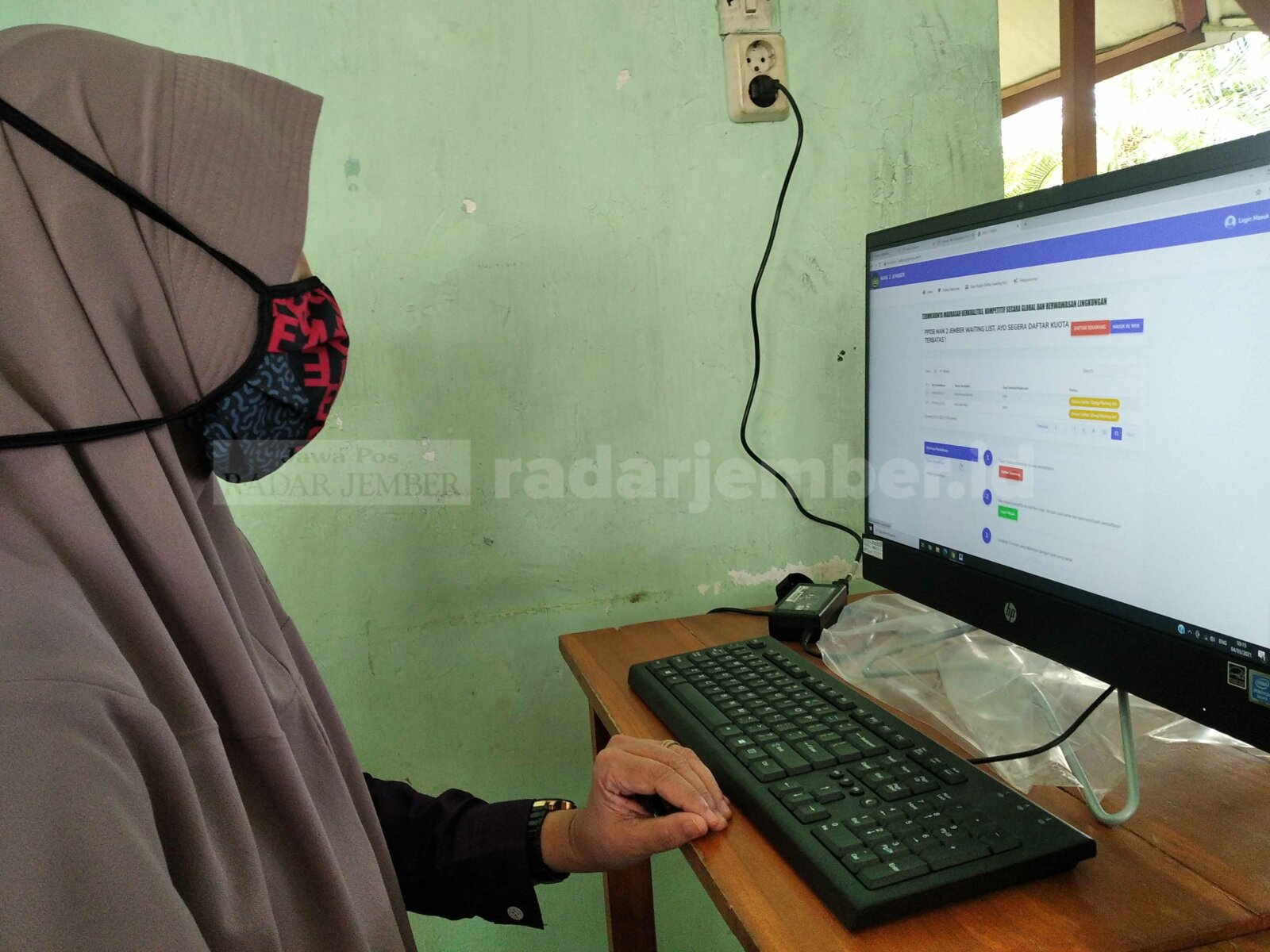 VIA DARING: Salah satu guru MAN 2 Jember tengah melakukan pengecekan data waiting list siswa yang akan mengikuti PPDB daring.