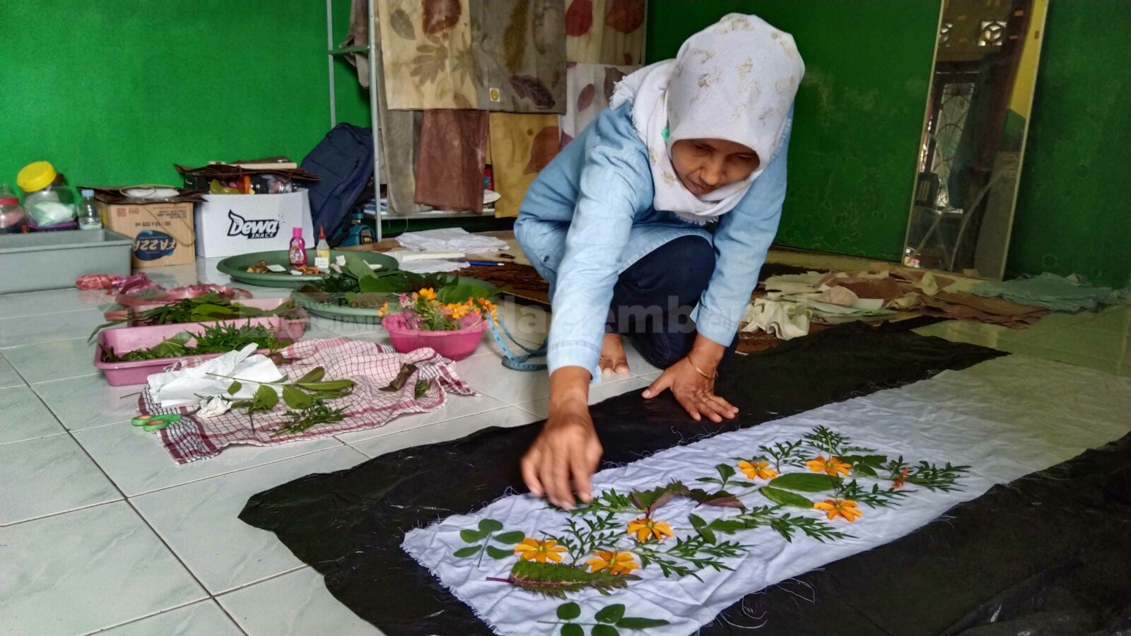 RAMAH LINGKUNGAN: Sri Agustini merangkai daun yang warnanya akan ditransfer ke kain putih, di rumahnya, Kelurahan Tegal Besar.
