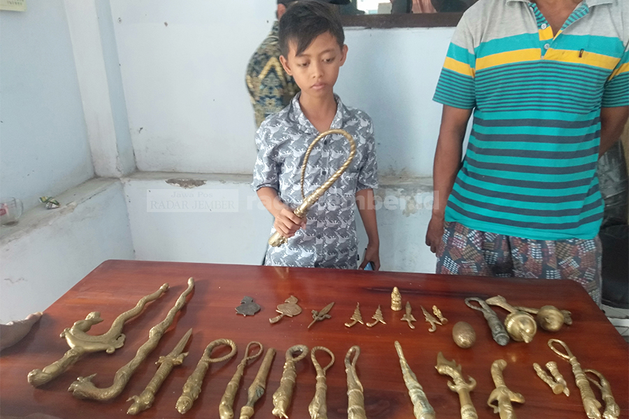 DIDUGA ARTEFAK: Sholeh, salah satu bocah penemu puluhan benda pusaka yang diduga artefak di Desa Selok Awar-Awar, Kecamatan Pasirian. Sementara ini, belum diketahui pasti keaslian 32 pusaka tersebut sehingga diamankan di kantor desa setempat.