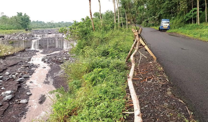 TERGERUS: Jalan Pasrujambe terancam putus. Sebab, tanggul Sungai Besuk Sat menggerus hingga menyentuh sisi jalan.