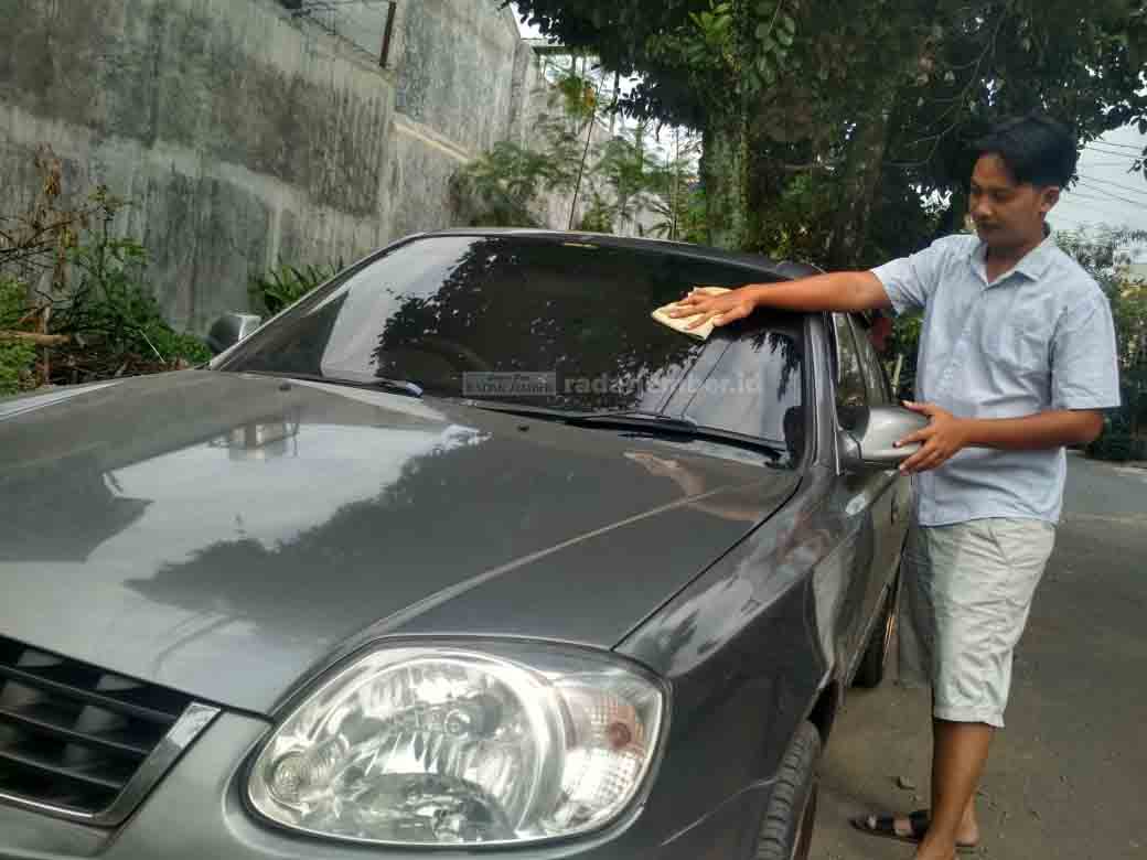 BERSIH-BERSIH: Rudy Hantoro tampak cermat dalam membersihkan salah satu mobilnya di halaman rumahnya, Jalan Letjen Suprapto, Lingkungan Krajan, Kelurahan Kebonsari, Kecamatan Sumbersari, kemarin (29/4).