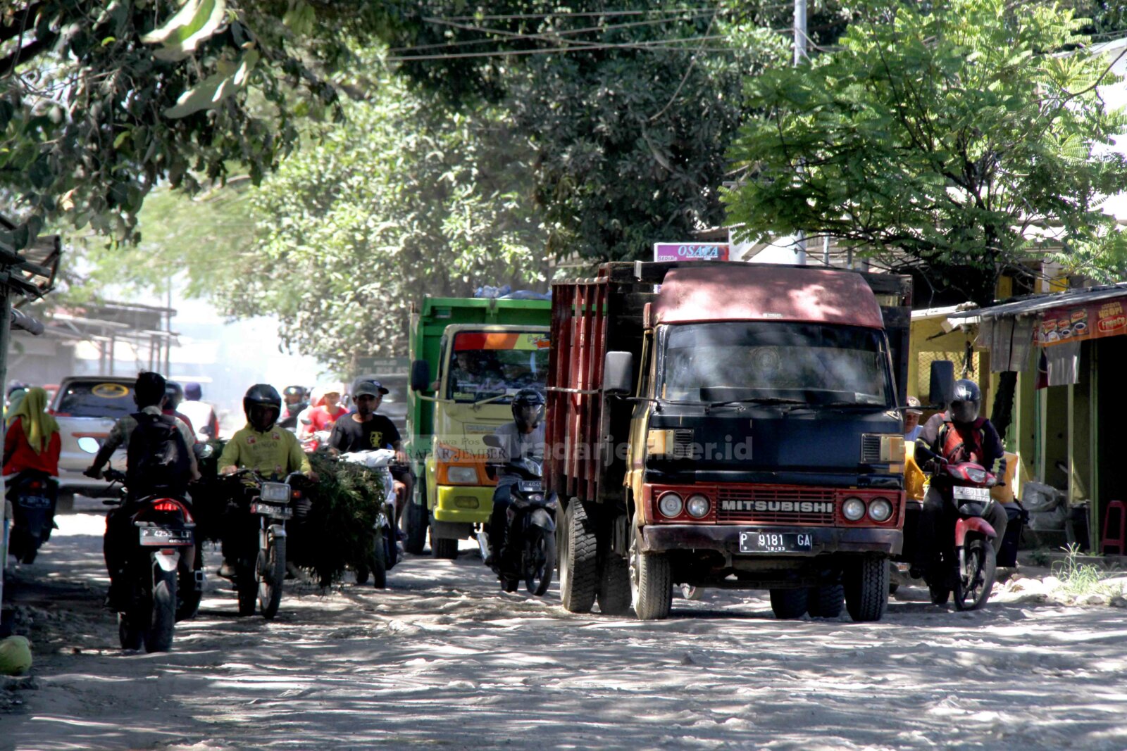 SUSAH LEWAT: Pengguna jalan yang melintas di jalan rusak sekitar Taman Makam Pahlawan (TMP) Ambulu. Mereka harus bersusah payah mencari jalan yang masih bisa dilewati.