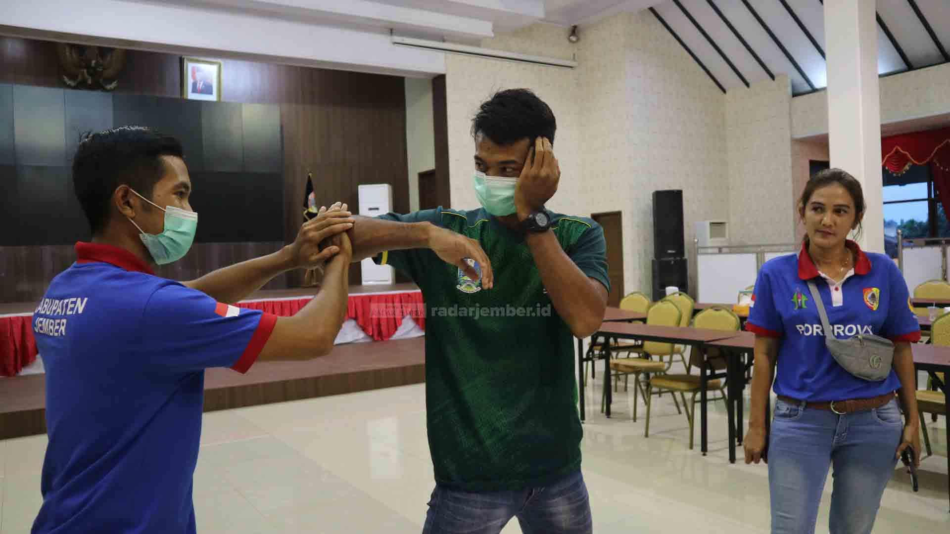 ATLET POTENSIAL: Abdulrahman (kanan) tengah menunjukan kemampuannya bersama pelatih di Pendapa Bupati Jember. Atlet muay thai dari Jember ini ditargetkan meraih medali emas di PON Papua mendatang.