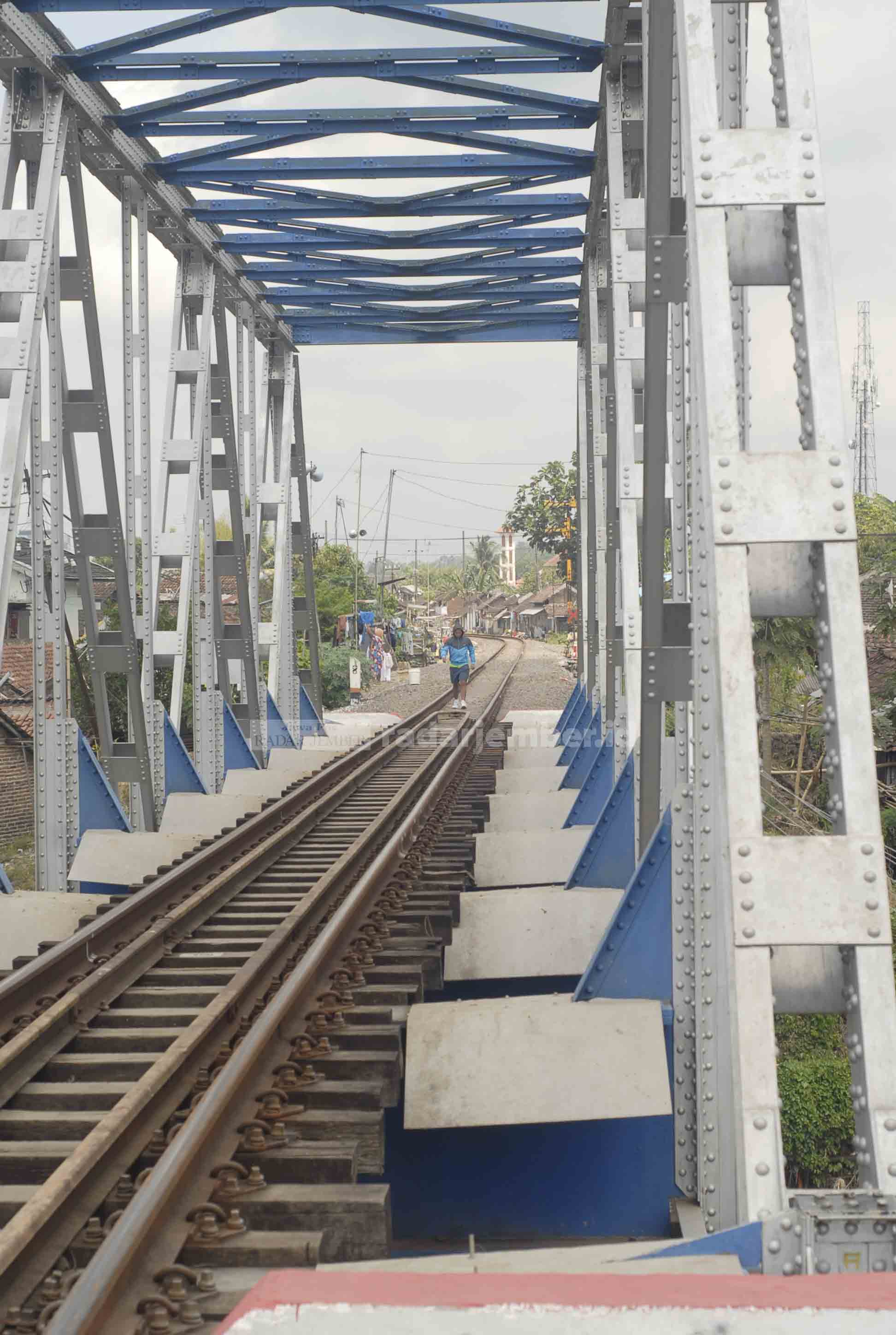 PERLU SOSIALISASI: Pengendara berhenti di depan salah satu perlintasan kereta api tanpa palang pintu di Jember. Wacana pembangunan double track perlintasan kereta api berpotensi menuai pro dan kontra di masyarakat, karena bakal menggusur permukiman.