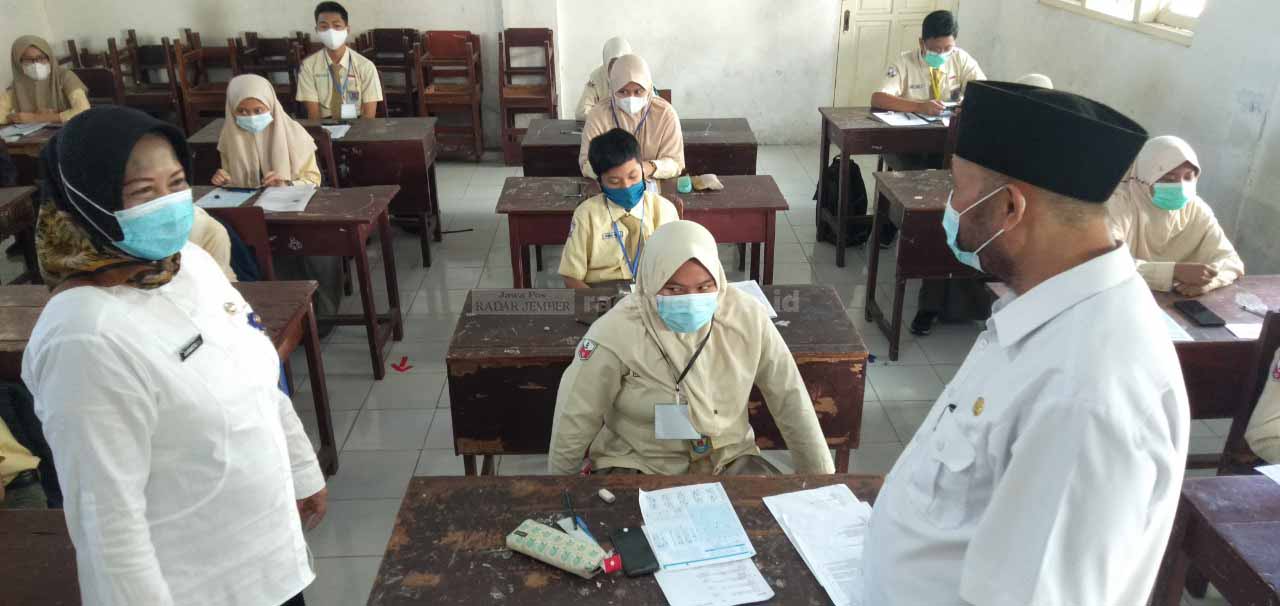 PANTAU PTM: Bambang Hariono Plt Ka Dinas Pendidikan Kabupaten Jember saat mentau pelaksanaan uji coba Pembelajaran Tatap Muka (PTM) di SMPN 6 Jember didampingi Suhartatik Plt Kepala Sekolah