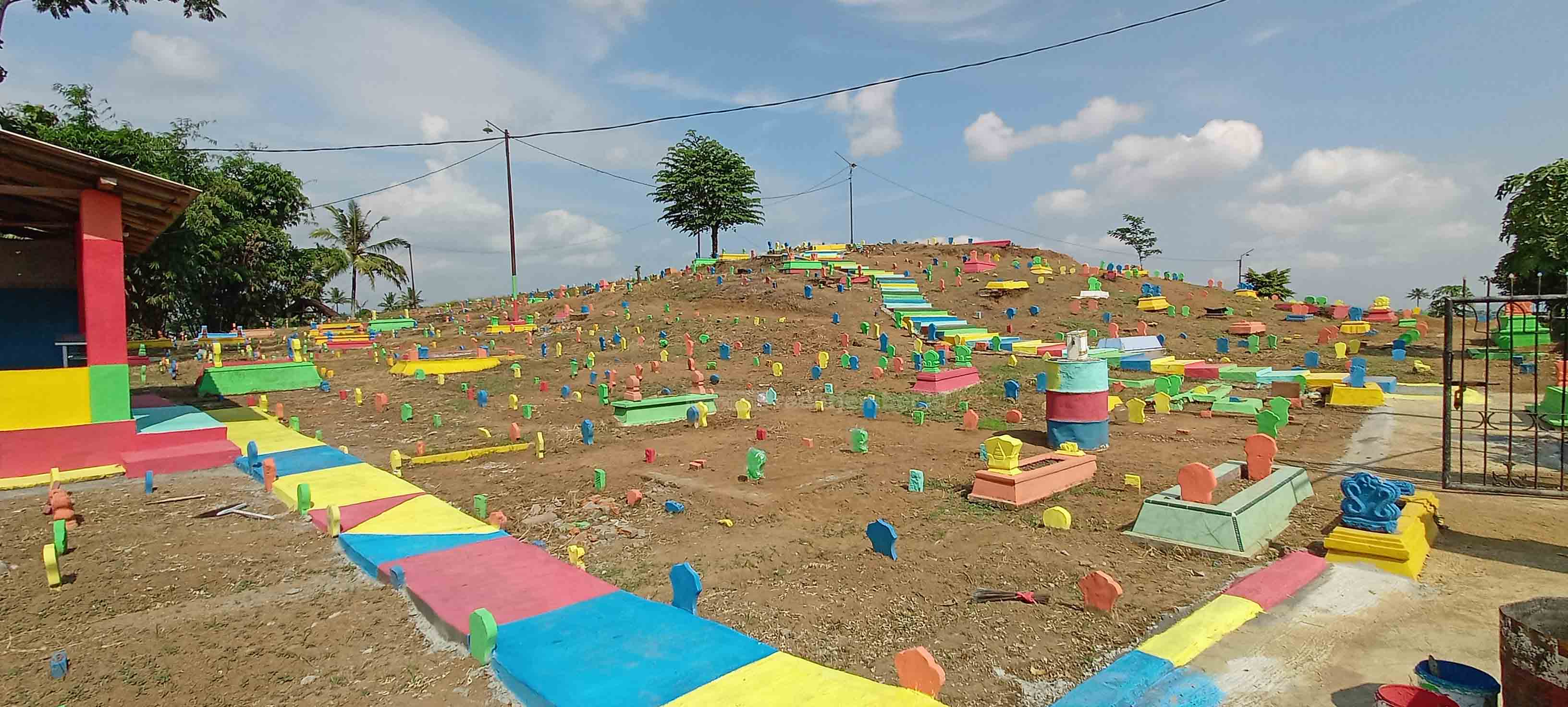 TAMPIL BEDA: Tempat pemakaman umum di Dusun Krajan, Desa/Kecamatan Jenggawah, yang tampak dicat penuh warna. Di Desa Wonojati, Kecamatan Jenggawah, ada pemakaman serupa yang juga dicat warna-warni.