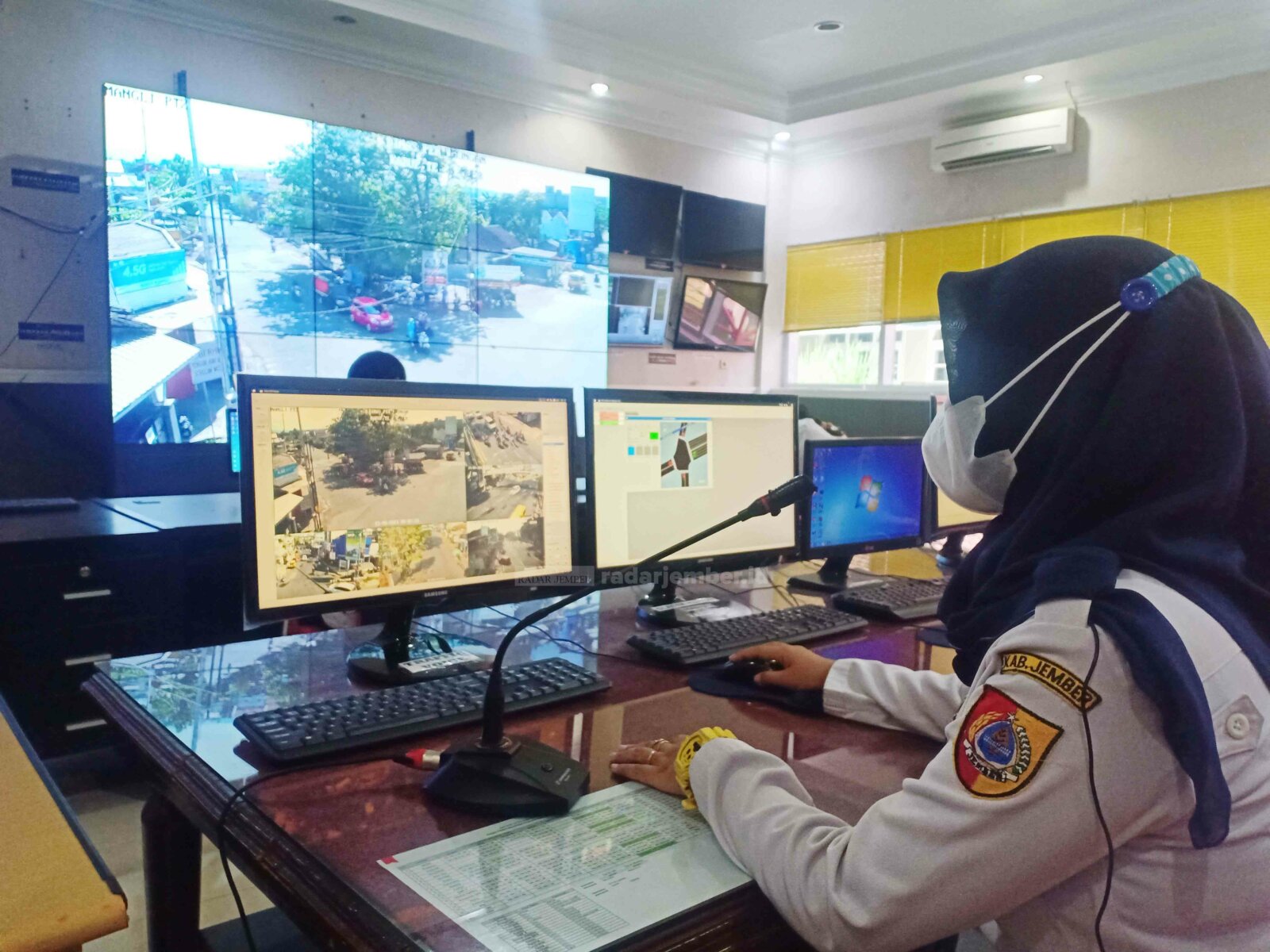 ATENSI: Salah seorang petugas di Traffic Manajemen Centre alias Ruang Pantau CCTV Dinas Perhubungan (Dishub) Jember, Agnes Cholifah, tampak mengimbau salah seorang pengendara motor yang melanggar rambu lalu lintas di perempatan Mangli, kemarin (21/5) pagi