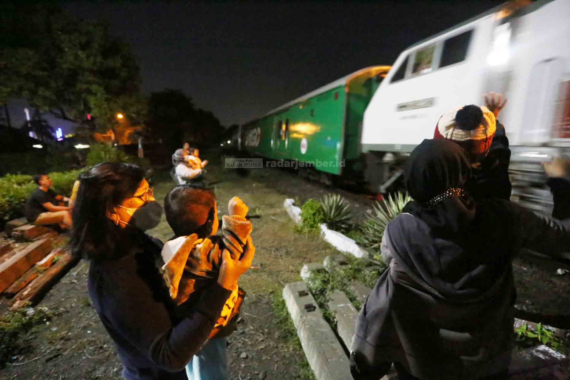 SAMBUT KEDATANGAN: Beberapa anak tampak melambaikan tangan saat menyambut kereta api yang hendak masuk Stasiun Jember di perlintasan kereta Jalan Mawar, Kelurahan Jember Lor, Patrang, belum lama ini.