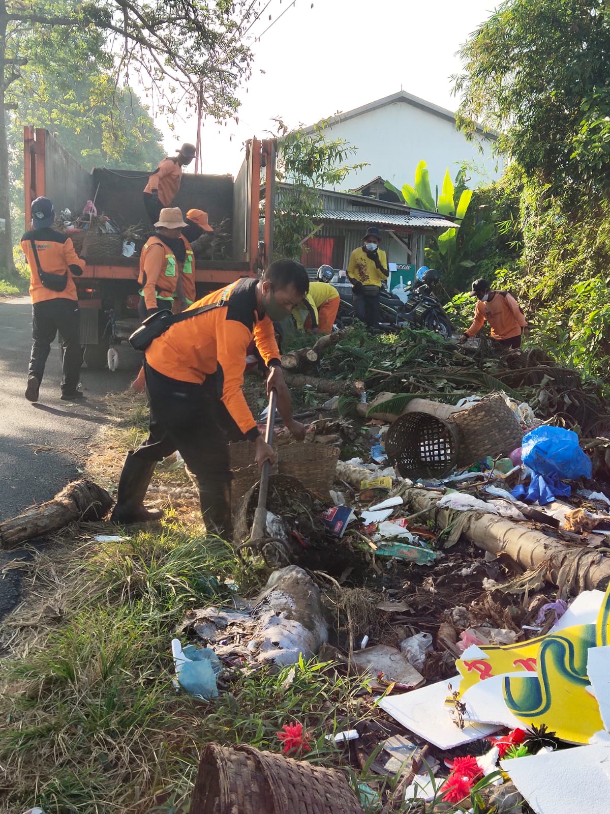 DIBERSIHKAN: Sejumlah petugas sampah dari Dinas Lingkungan Hidup (DLH) Lumajang membersihkan tumpukan sampah di samping Jalan Bromo, Tompokersan, Lumajang, kemarin.