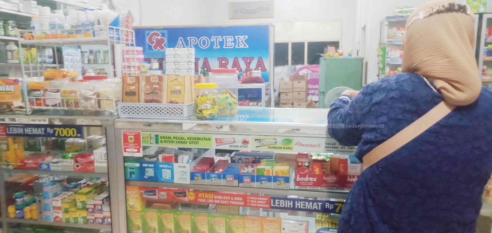 DILAYANI: Salah seorang penjaga apotek di Bondowoso sedang melayani pembeli.