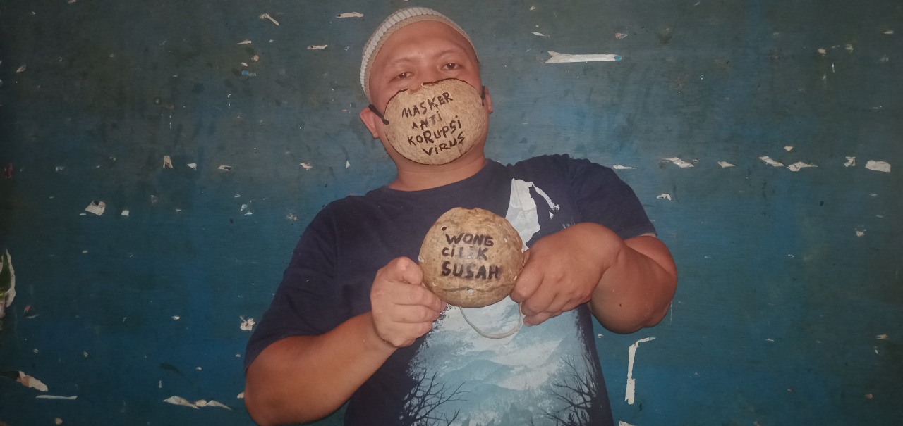 NYELENEH: Andri Widodo, difabel penjual kelapa di Pasar Tanjung memiliki ide kreatif membuat masker dari tempurung kelapa.