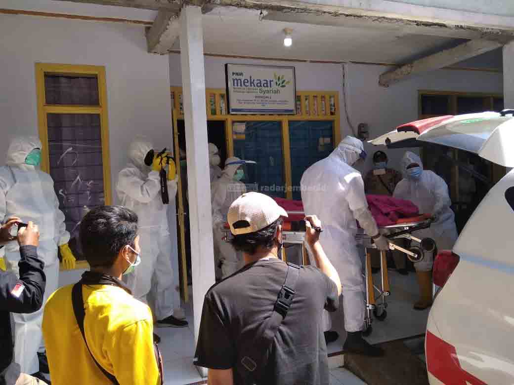 EVAKUASI: Para petugas sedang mengeluarkan jenazah yang diduga keracunan asap genset dari tempat kejadian perkara. Kemudian, dibawa ke rumah sakit menggunakan ambulans.